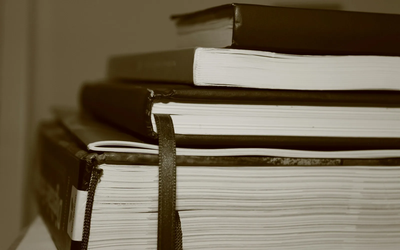 Expedientes encuadernados y atados con cinta, apilados de canto.